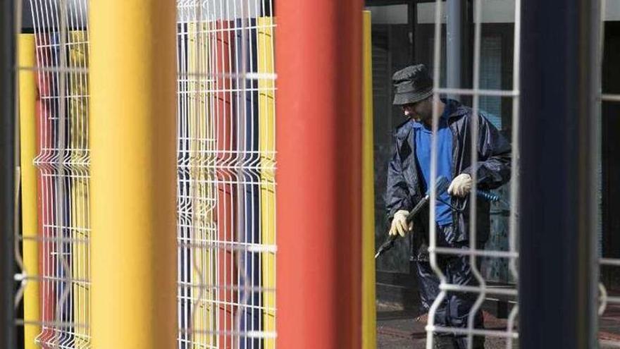 Un operario, ayer, durante las labores de limpieza del patio de la escuela infantil de Colloto.