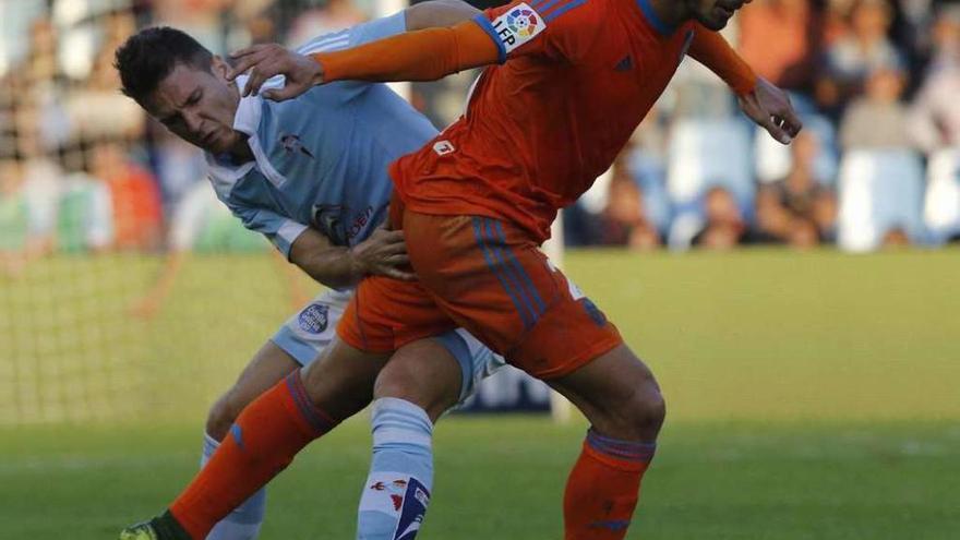 Radoja pugna con el portugués André Gomes durante la última visita del Valencia a Balaídos. // FDV