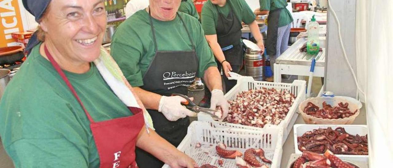 Dos mujeres cortan el pulpo para prepararlo á feira en una de las ediciones anteriores. // S.Álvarez