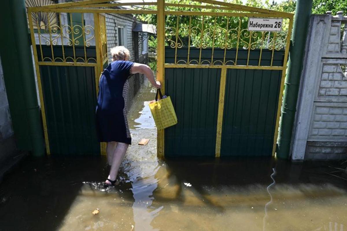 Los voluntarios entregan alimentos a los residentes locales en un área inundada, en medio del ataque de Rusia a Ucrania, en Kherson