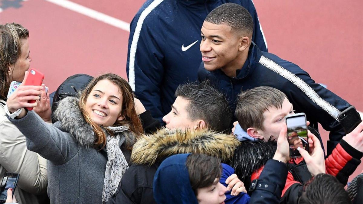 Mbappé fotografiándose con unos aficionados después de un entreno