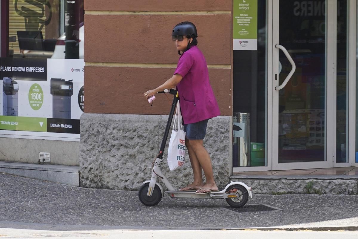 Una usuària amb casc, tot i que per la vorera del carrer de la Rutlla de Girona.