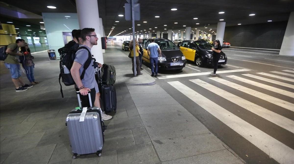 Unos pasajeros se hallan sin taxi para acceder al centro de Barcelona.