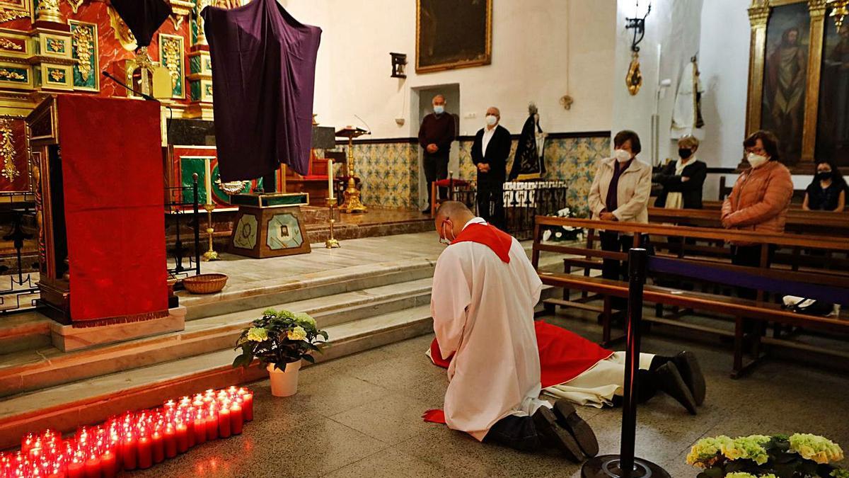 El vicario se arrodilla y el párroco se postra al comienzo del oficio de la Pasión.