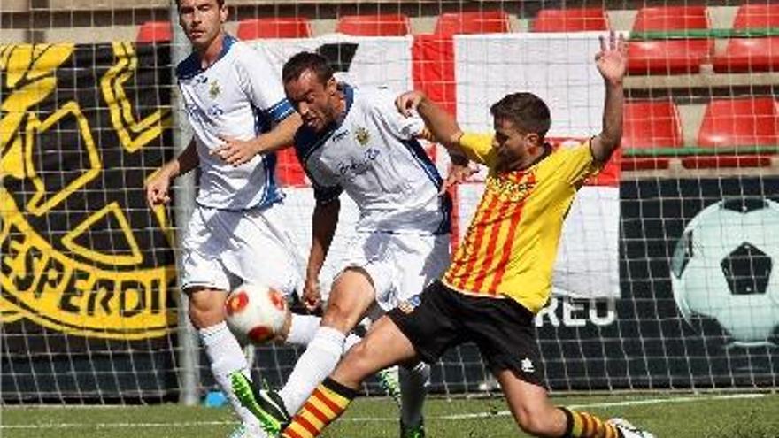 Tarradellas colpeja la pilota davant la pressió d&#039;un jugador del Sant Andreu, ahir al migdia al Narcís Sala.