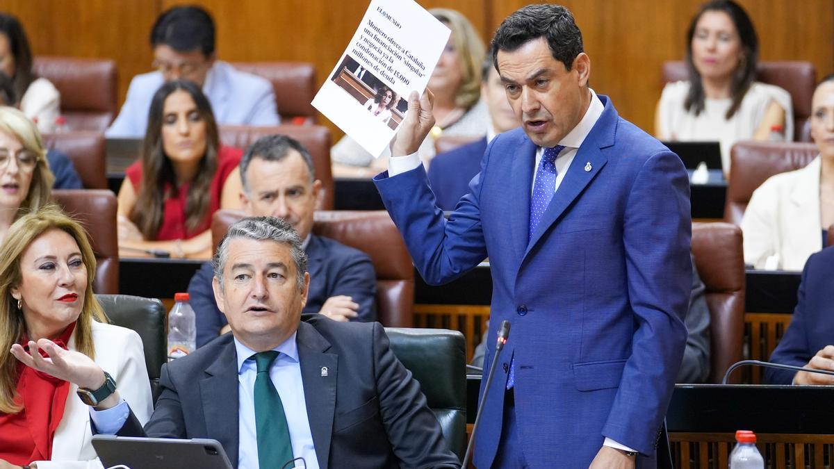 El presidente andaluz, Juanma Moreno, se enfrenta en el Parlamento contra el PSOE por la financiación autonómica.