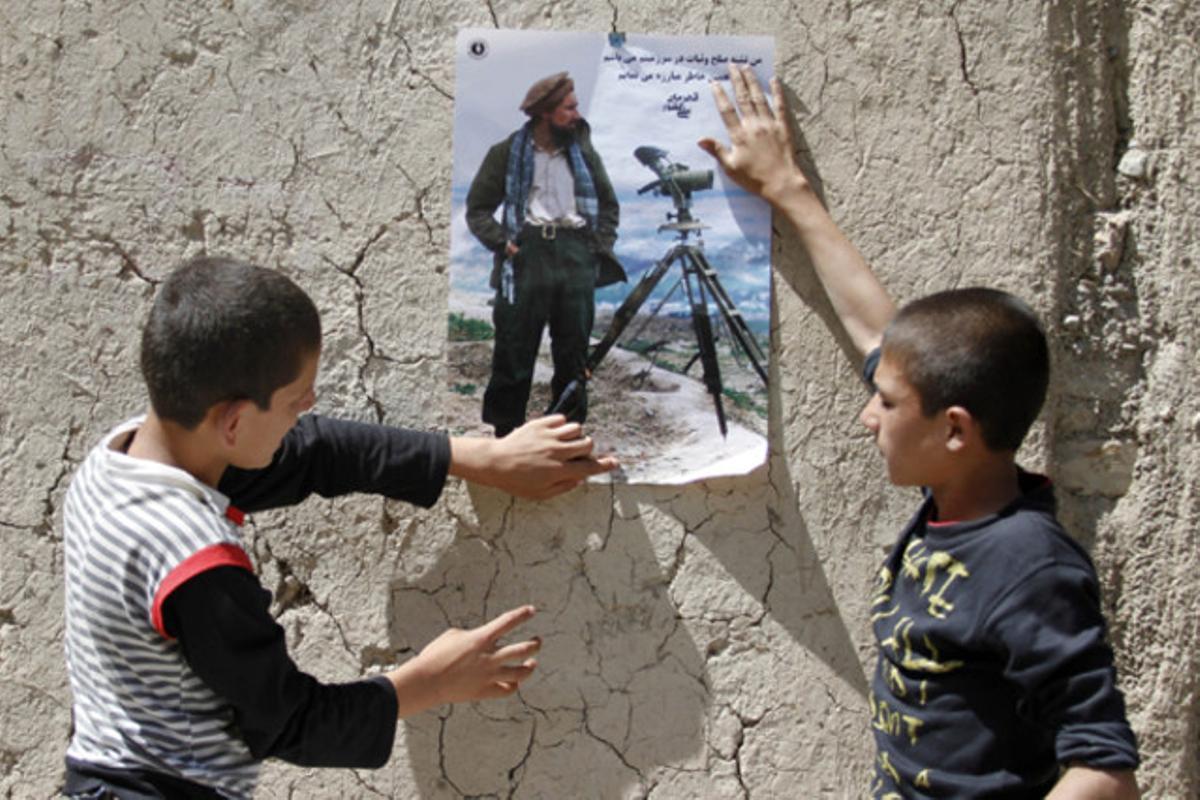 Nens afganesos enganxen un pòster de l’heroi nacional afganès, Ahmad Shah Massoud, en un poble de la província de Panjshir (Afganistan).