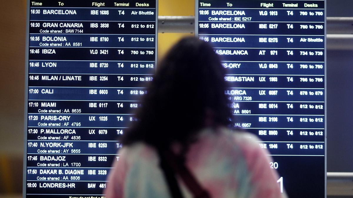 Una mujer observa un panel informativo del aeropuerto Adolfo Suárez-Madrid Barajas.