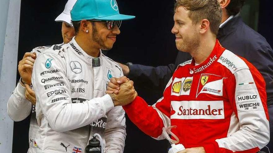 Vettel y Hamilton se saludan tras una carrera. // Efe