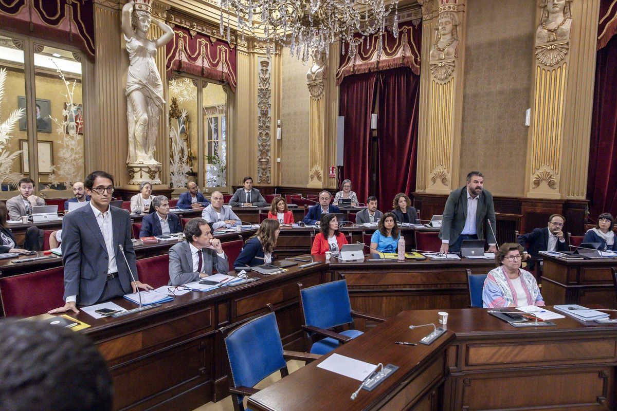 Iago Negueruela y, a la derecha, Lluís Apesteguia, ambos de pie, en el Parlament balear.