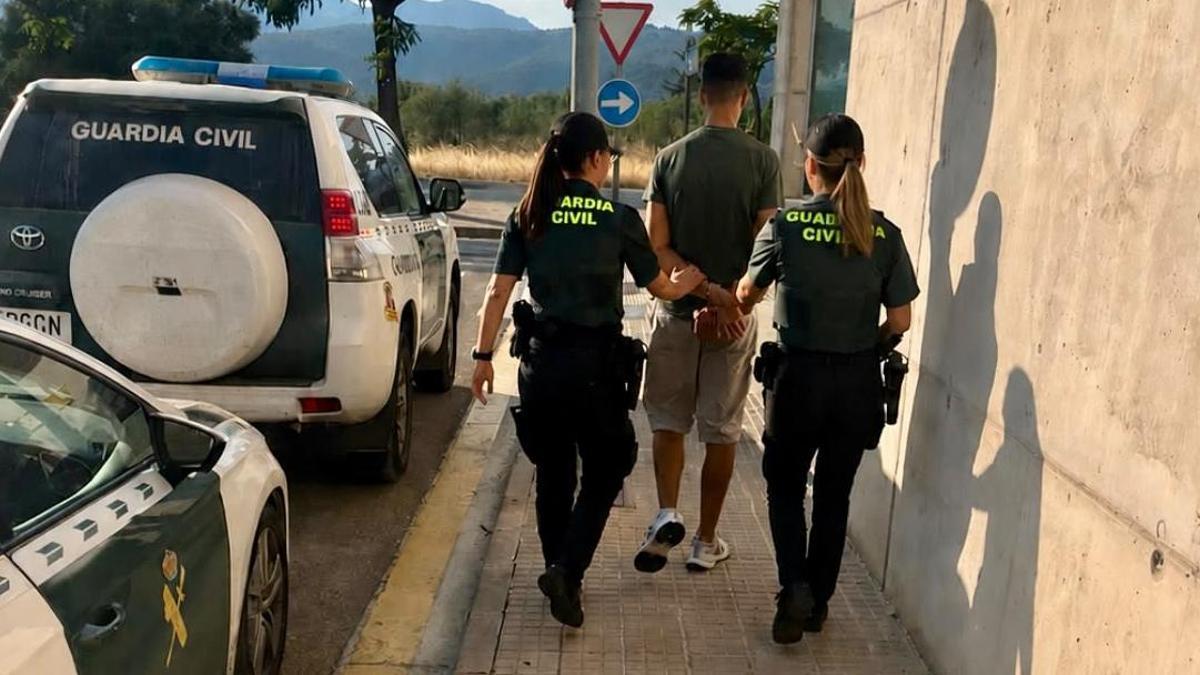 Dos agentes trasladan al sospechoso.