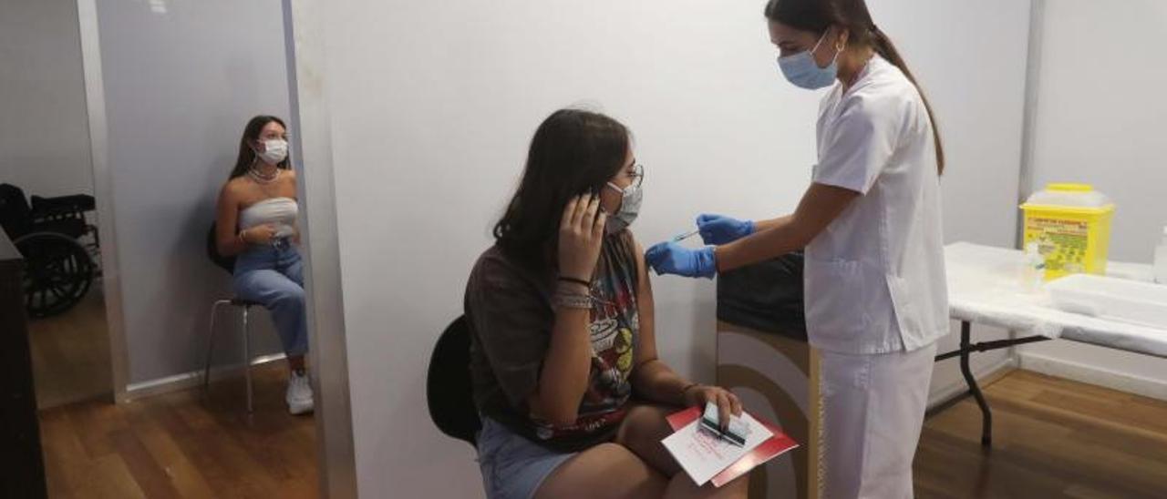 Dos jóvenes reciben la vacuna, tras iniciarse el proceso para el grupo de entre 16 y 19 años de edad, ayer en Xàtiva. | JM LÓPEZ