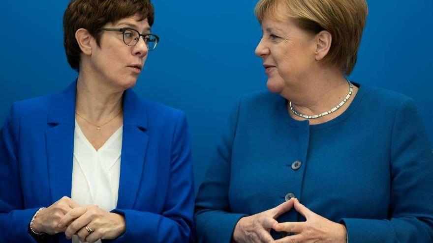 La ministra de Defensa, Kramp-Karrenbauer (CDU), conversa, ayer, con la canciller Angela Merkel. // Efe