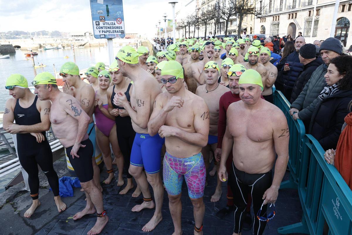 La travesía a nado de Navidad en Gijón congrega un año más a decenas de participantes (en imágenes)