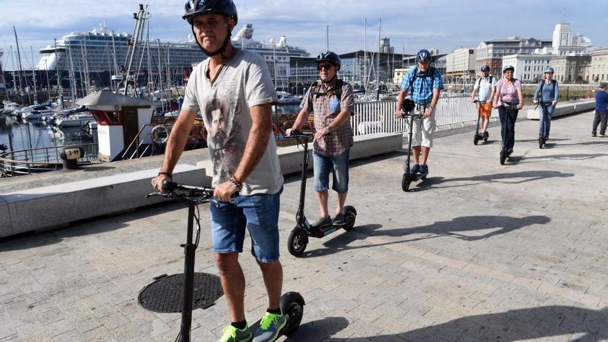 Un grupo de turistas con patinetes eléctricos en A Coruña.