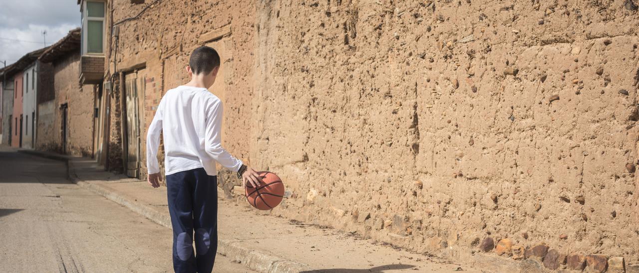 Un niño juega en las calles de un pueblo de la España vaciada.
