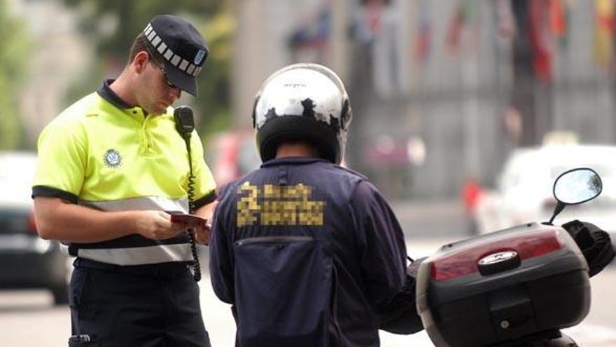 Un agente de movilidad de Madrid pide los papeles a un motorista. | lp / dlp