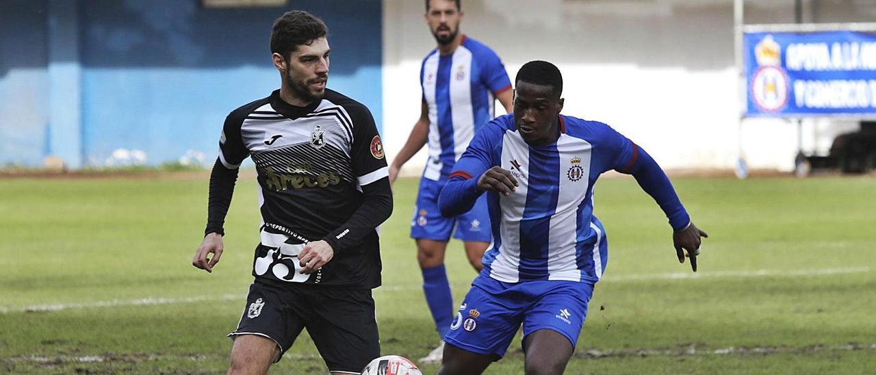 Cali, a la izquierda, lucha por un balón con el jugador del Real Avilés Alagy Oliveira. | Ricardo Solís