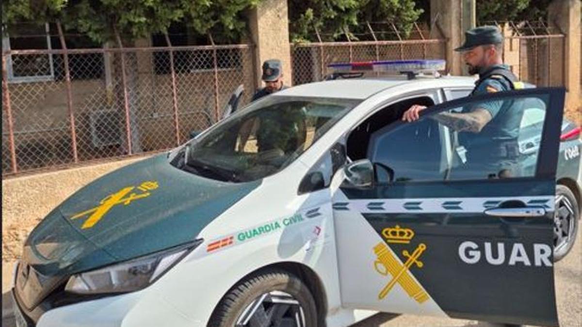 Dos agentes de la Guardia Civil, en el coche patrulla.