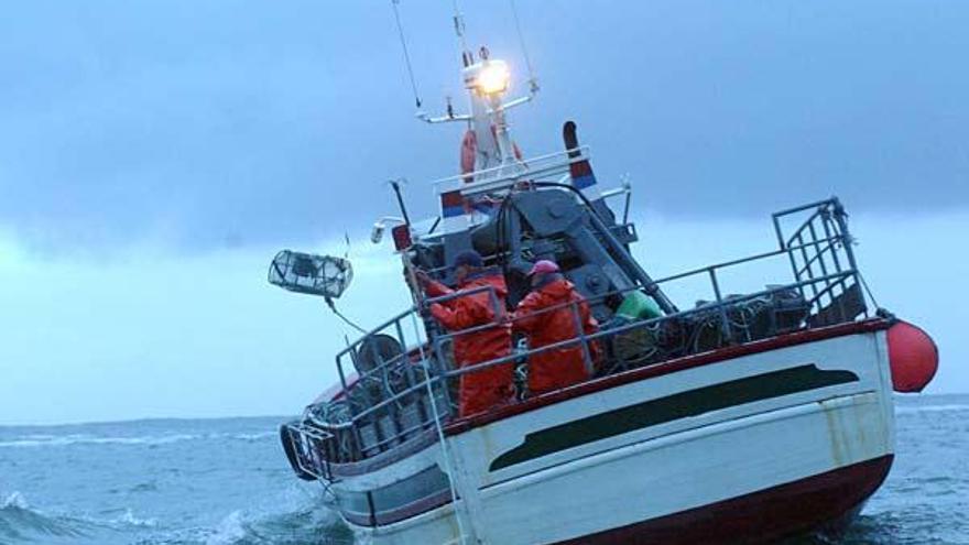 Dos marineros gallegos lanzan nasas al mar para la captura de pulpo.  //J.L. Oubiña