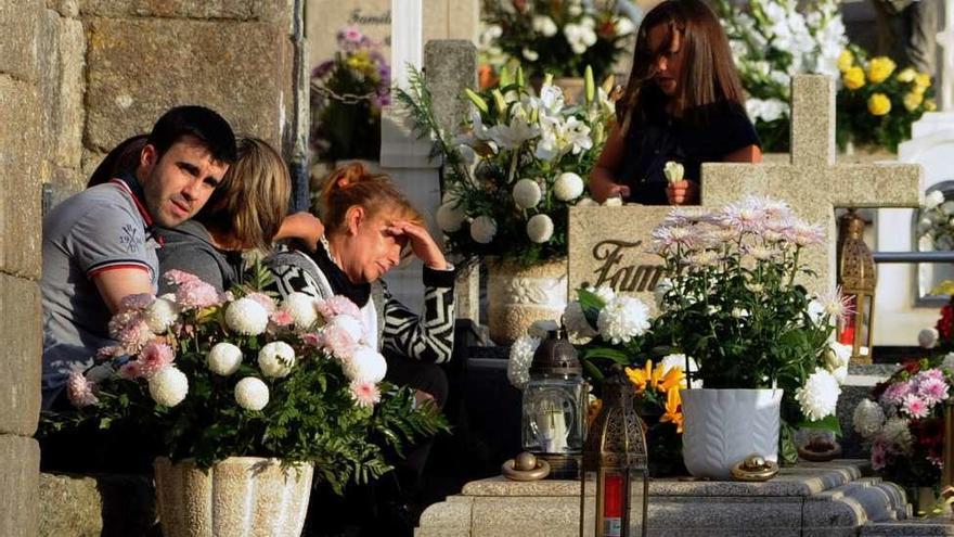 Vecinos al lado de la sepultura de un familiar, en Santa Mariña. // Iñaki Abella