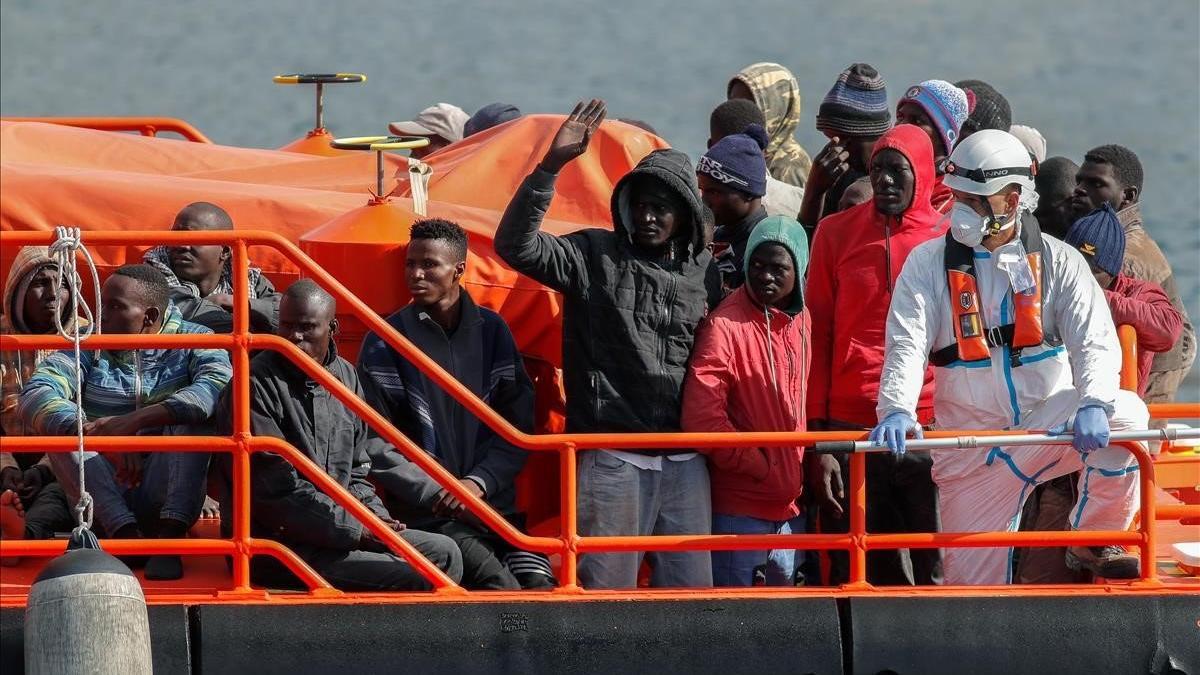 Un grupo de migrantes subsaharianos esperan para desembarcar en Gran Canaria tras ser rescatados en alta mar.