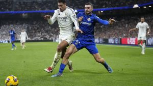 Real Madrids Jude Bellingham, left, and Getafes Juan Iglesias vie for the ball during the Spanish La Liga soccer match between Real Madrid and Getafe at the Santiago Bernabeu Stadium in Madrid, Spain, Sunday, Dec. 1, 2024. (AP Photo/Bernat Armangue)
