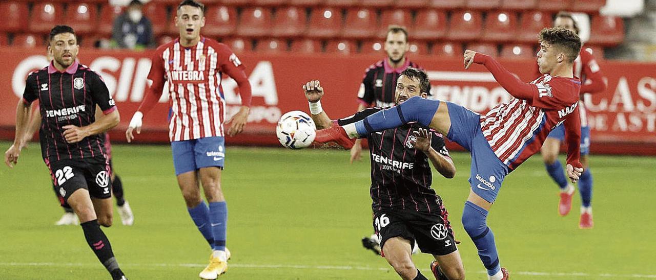 Nacho Méndez golpea un balón ante Aitor Sanz, con Pedro y Zarfino al fondo.