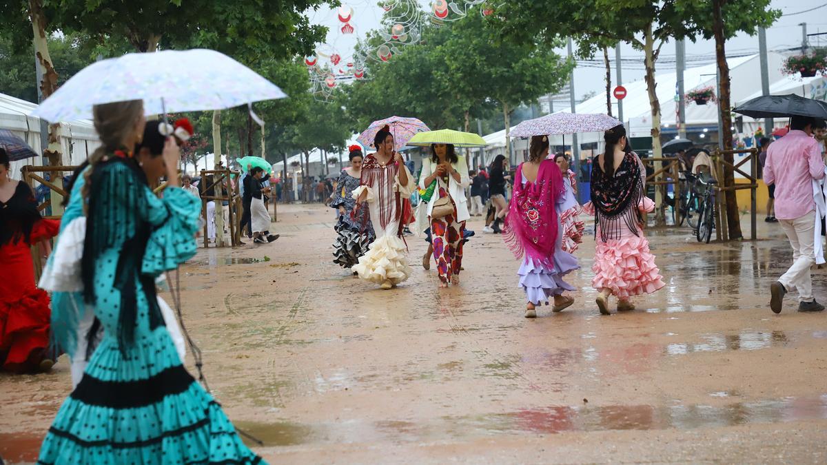 Varias mujeres vestidas de flamenca, ayer en El Arenal.