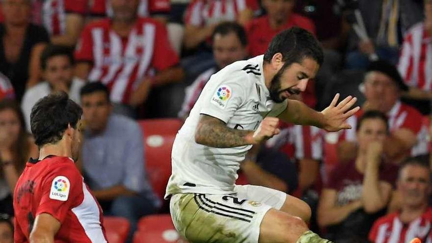 Isco Alarcón salta ante la llegada de Mikel San José, durante el partido de ayer en San Mamés. // Lluis Gené