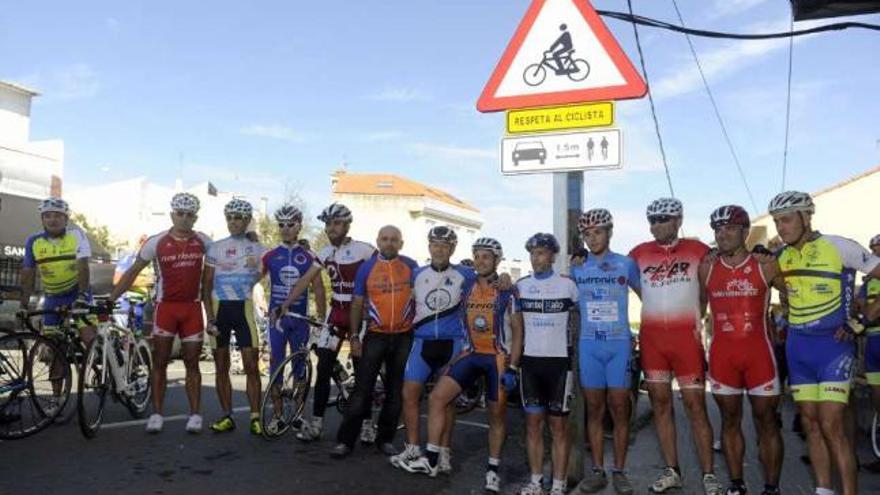 Grupo de ciclistas, ayer, bajo la señal ubicada en Oleiros. / juan varela