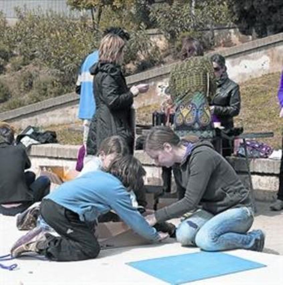 L’empremta 8 Un grup de nens pinten a terra a la plaça, al març.