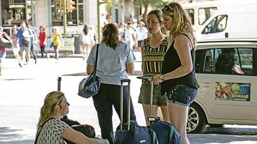 Imagen de turistas con sus maletas en el centro de Palma.