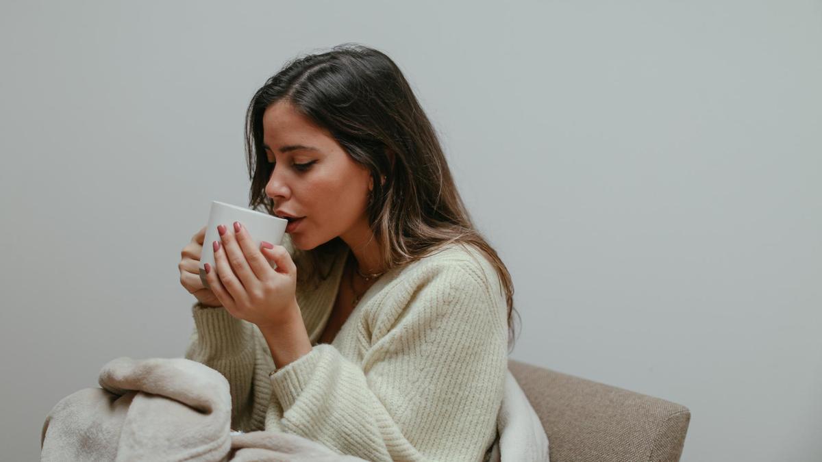 Una mujer bebiendo una taza de té.