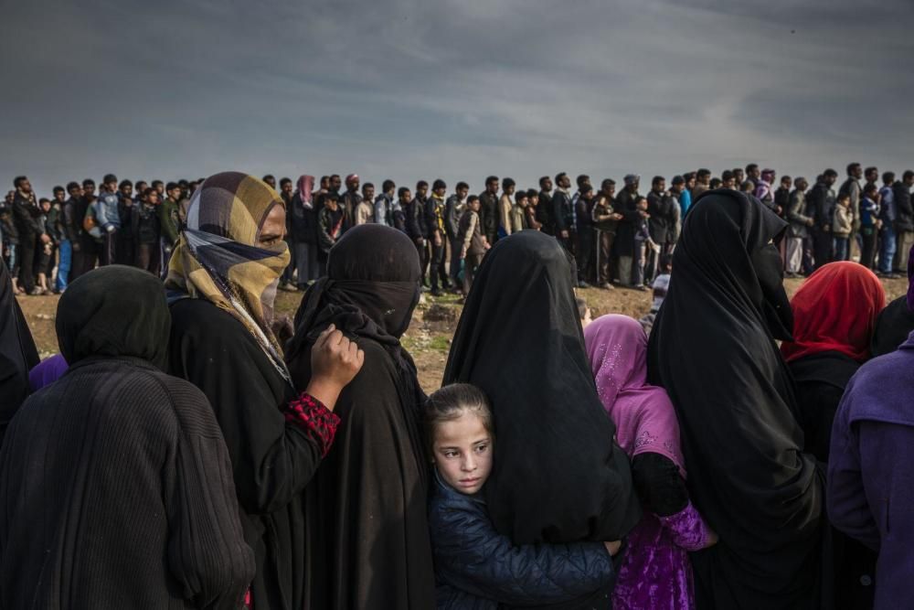 Civiles que se habían quedado en el oeste de Mosul después de la batalla para tomar la línea de la ciudad en busca de ayuda en el barrio de Mamun.