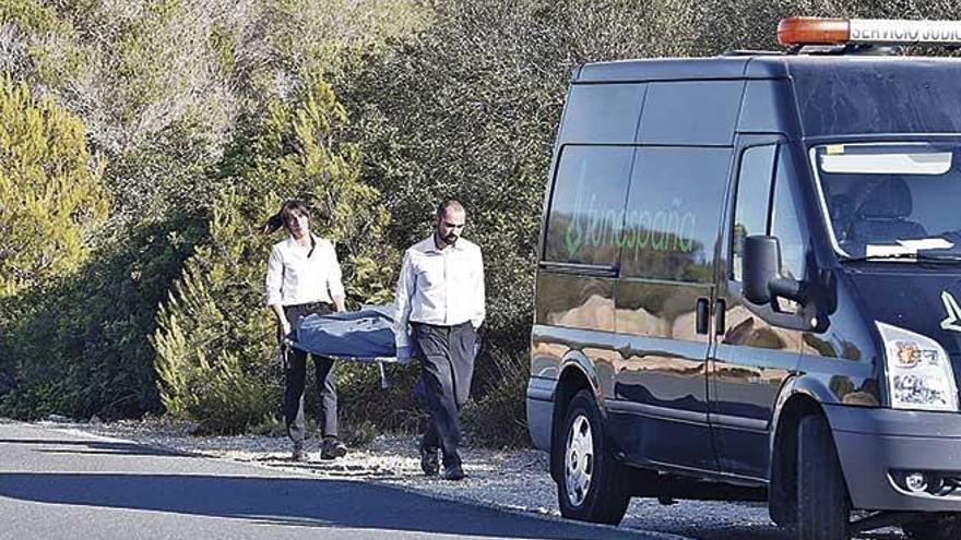 Operarios de los servicios funerarios trasladan el cadÃ¡ver encontrado ayer en la carretera de Cap Blanc.