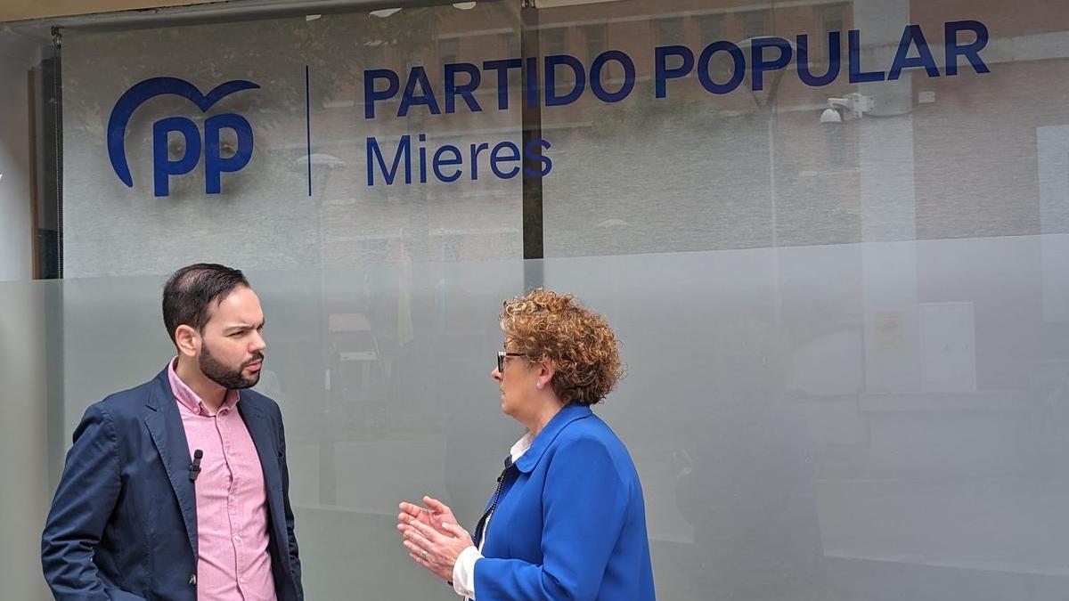 Víctor Ferreira y Gloria García, ante la sede del PP en Mieres.