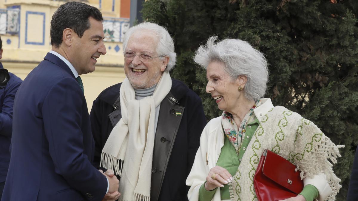 Juanma Moreno saluda a la poeta Rosa Díaz y al fundador del partido Andalucista Alejandro Rojas-Marcos.