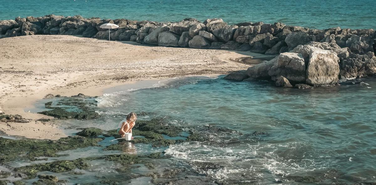 LA FOTO CONTADA | Miradas sobre el mundo: Una niña juega en la playa del Molinar.