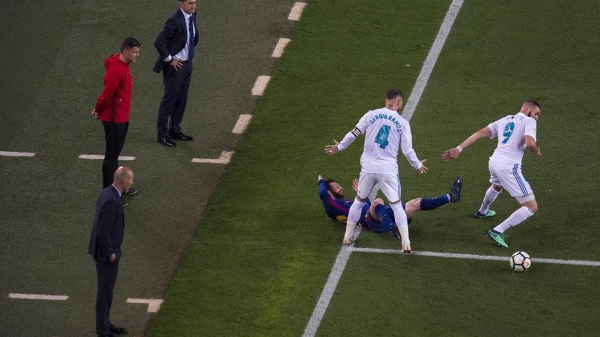 Ramos derriba a Messi en la banda ante la mirada de Valverde y Zidane durante el  clasico  partido de liga entre FC Barcelona y Real Madrid