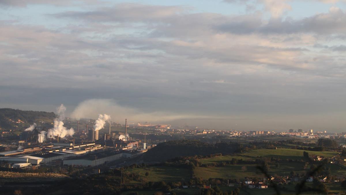 A la izquierda, factoría de ArcelorMIttal en Gijón, con la ciudad a la derecha de la imagen.