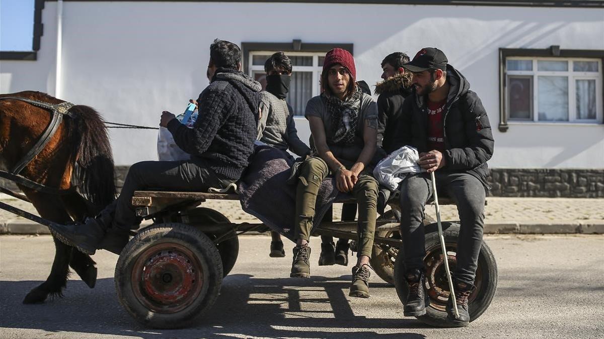 Un grupo de migrantes viajan en un carro en las inmediaciones de la localidad turca de Pazrkule, en la frontera con Grecia.