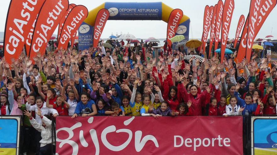 Participantes en una jornada deportiva, tras el cartel de «Gijón deporte». |
