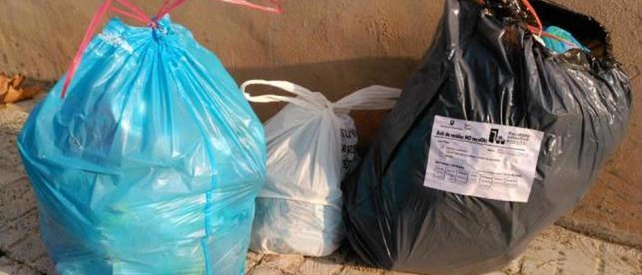 Bolsas de basura en plena calle, sacadas el día que no tocaba y con una advertencia pegada.