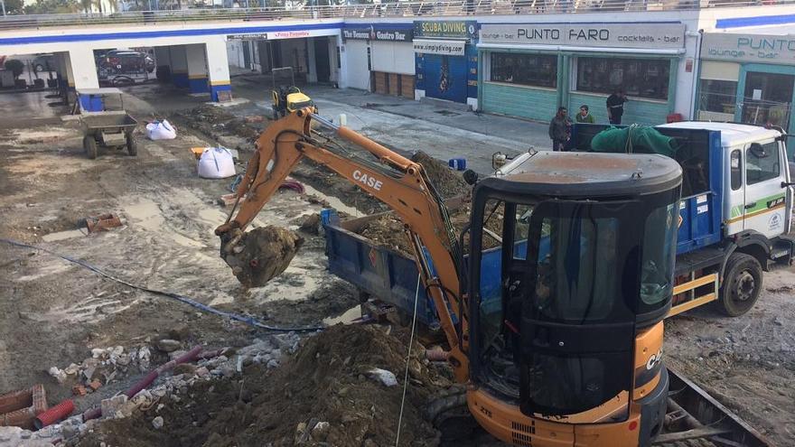 Operarios trabajan en las obras para construir un bulevar en el puerto deportivo de Marbella.