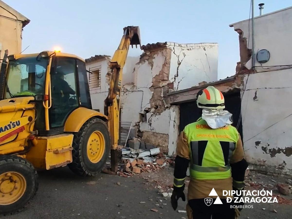 Labores de derribo de una vivienda en Épila, que ha obligado a desalojar a los vecinos de una casa.