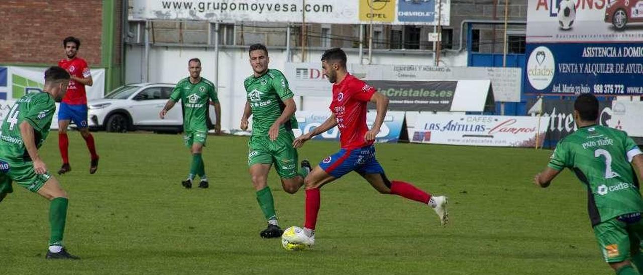 Pedrosa, rodeado de jugadores del Arenteiro durante el partido de la primera vuelta. // Carlos Peteiro