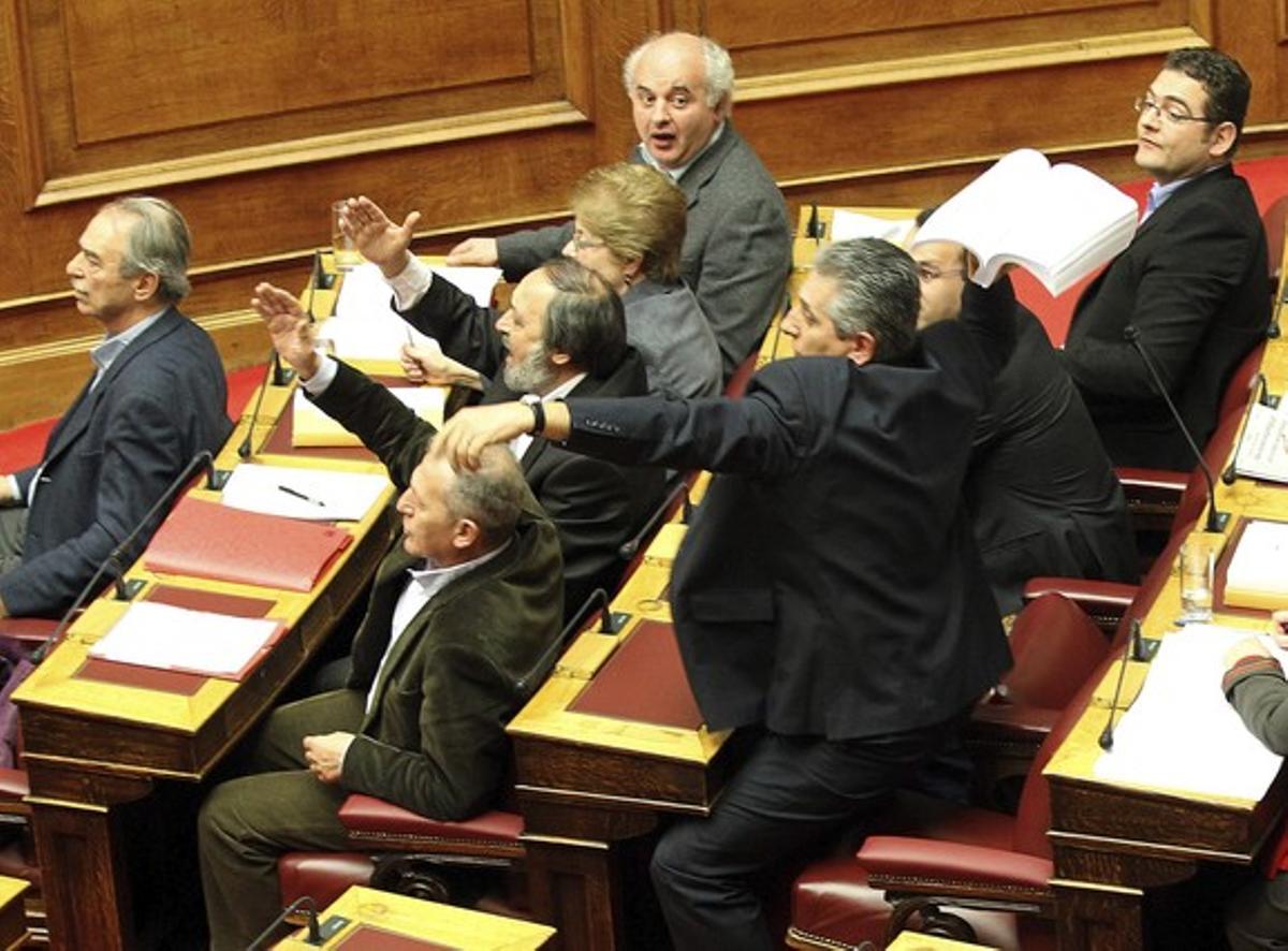 El líder dels comunistes grecs, Girogos Mavrikos, llança l’esborrany de l’acord en plena sessió del Parlament. El líder dels comunistes grecs, Girogos Mavrikos, llança l’esborrany de l’acord en plena sessió del Parlament.