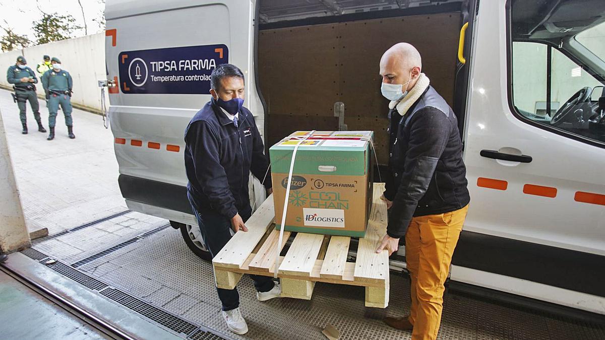 Dos trabajadores de la empresa de distribución descargan uno de los lotes con dosis de la vacuna de Pfizer, el domingo 27.  | LEVANTE-EMV