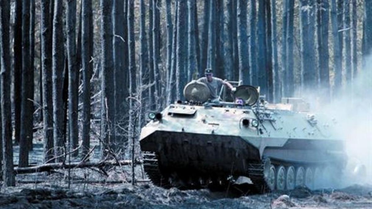 Soldados rusos conducen un tanque a través de un bosque quemado cerca de Voronezh, ayer.